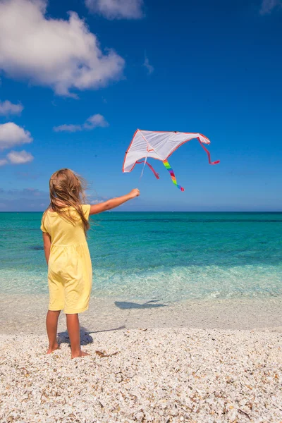 Petite fille mignonne jouant avec cerf-volant volant sur la plage tropicale — Photo