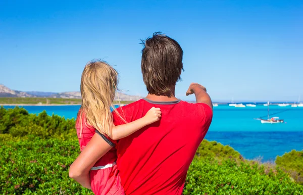 Junger Vater und seine kleine Tochter genießen die schöne Aussicht auf das türkisfarbene Meer auf der Insel Sardinen — Stockfoto