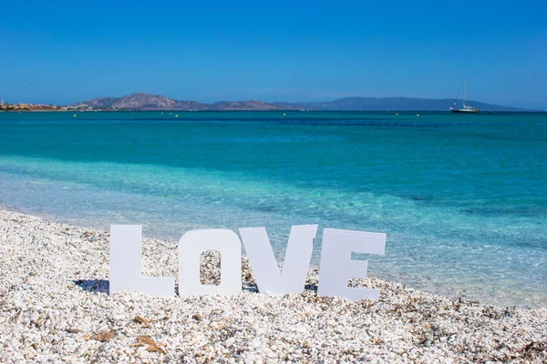 Word love on tropical beach background of the turquoise sea and blue sky — Stock Photo, Image