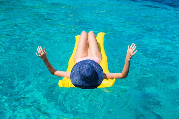 Женщина отдыхает на надувном матрасе в море — стоковое фото