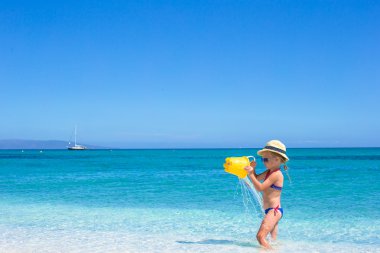 sevimli küçük kız var eğlenceli plaj oyuncak ile tropikal plaj