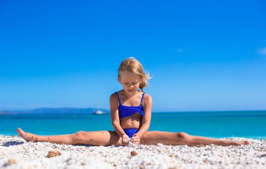 sevimli küçük kız bacak-split yapma tropikal beyaz kumlu plaj ve yaz tatil keyfi