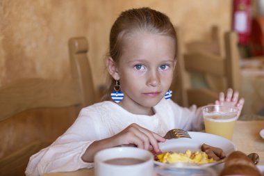 sevimli küçük kız resort restoranda kahvaltı yapıyor