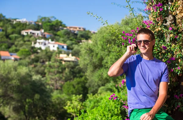 Young man talking on the phone at the balcony — Stock Photo, Image