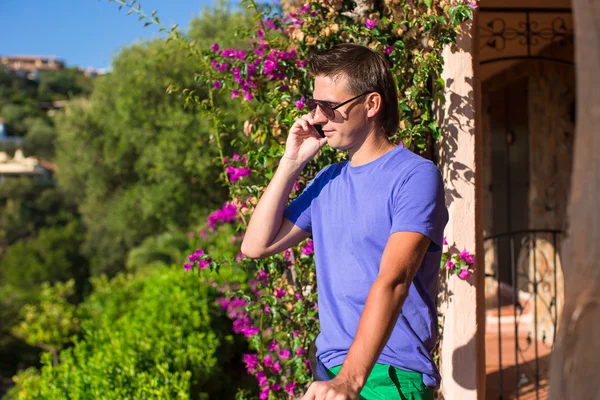 Young man talking on the phone at the balcony — Stock Photo, Image