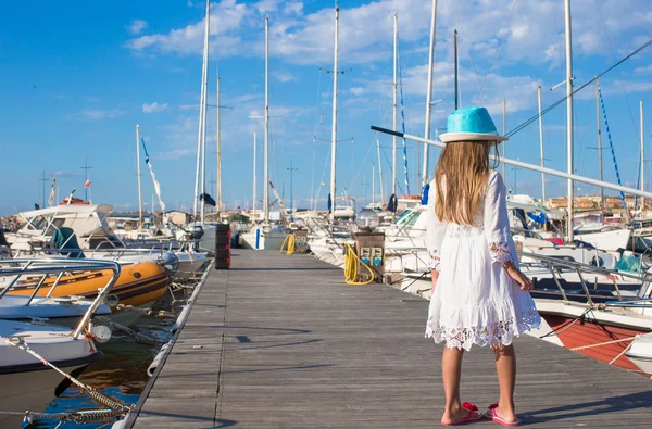 Bedårande liten flicka ha roligt i en port på sommardag — Stockfoto