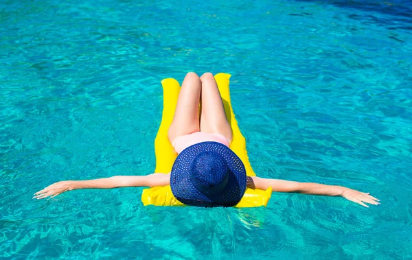Молодая привлекательная девушка плавает на надувном матрасе в чистом море — стоковое фото