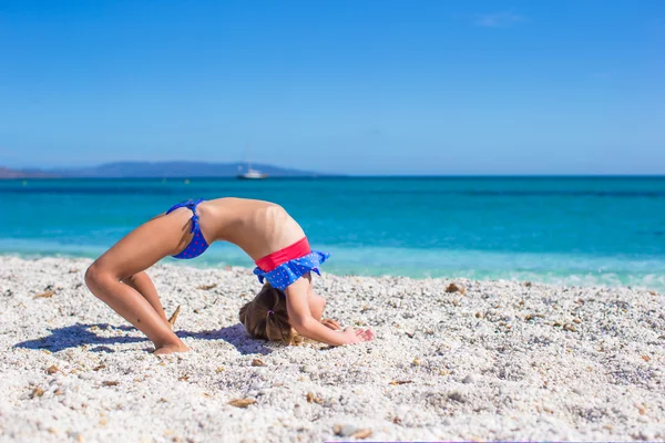 Cute little sporty girl on white tropical beach and having fun — Stock Photo, Image