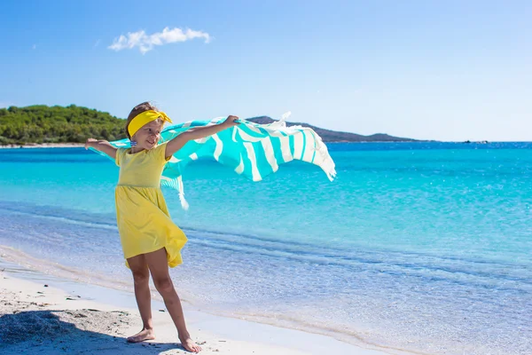 Küçük güzel bir kız var çok mutlu ve eğlenceli plaj havlusu ile — Stok fotoğraf