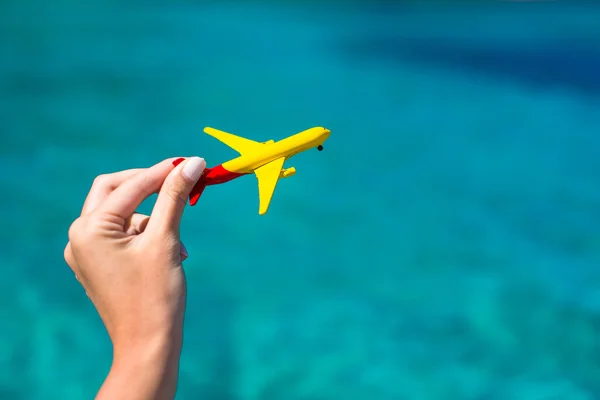 Small homemade plane in female hand on background of the sea — Stock Photo, Image