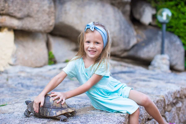 Klein adorble gelukkig meisje met een schildpad buitenshuis — Stockfoto