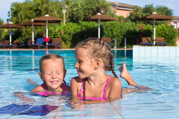 Bonito meninas felizes se divertindo na piscina — Fotografia de Stock