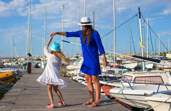 Young mother with little pretty girl in the port enjoying sunny summer day — Stock Photo, Image