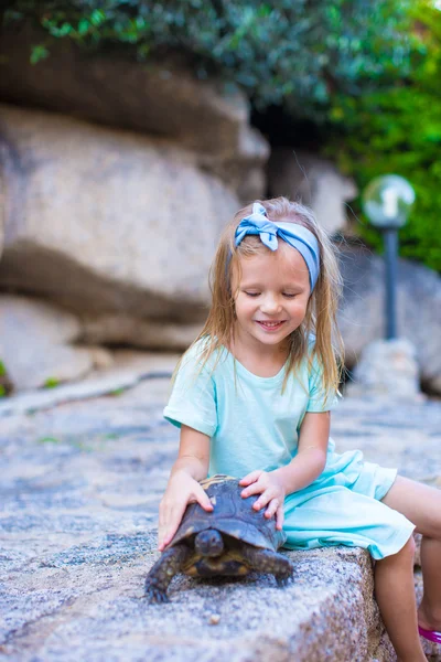 Little adorble happy girl with a turtle outdoors — Stock Photo, Image