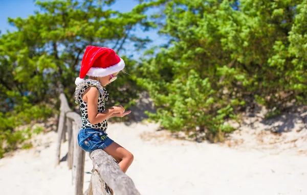 Bonita menina bonita em chapéu de Santa durante a vavação — Fotografia de Stock