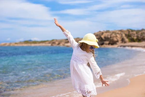 Очаровательная маленькая девочка веселится на тропическом пляже во время отпуска — стоковое фото