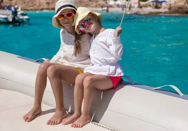 Portret van weinig cute meisjes genieten van zeilen op boot in de open zee — Stockfoto