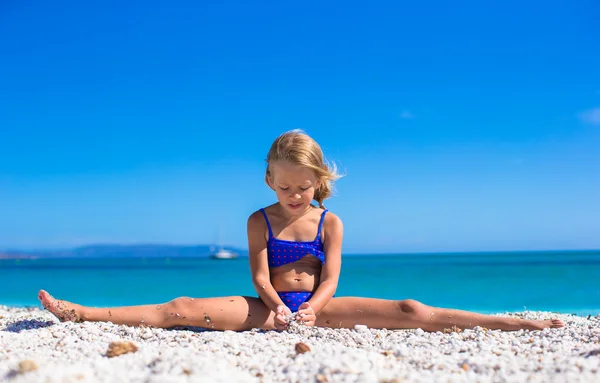 Adorable niña haciendo leg-split en la playa tropical de arena blanca y disfrutando de las vacaciones de verano —  Fotos de Stock