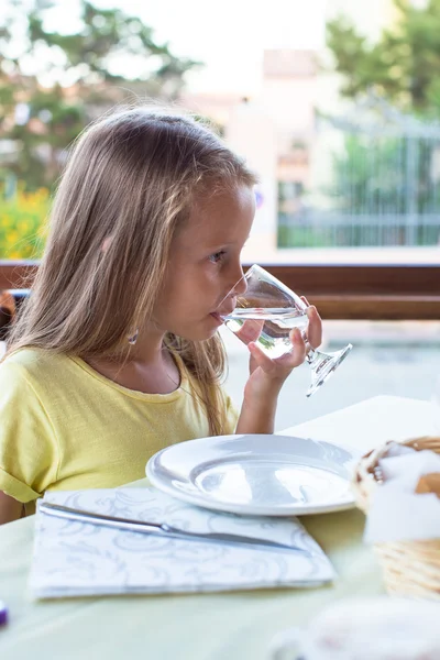 Adorable niña desayunando y bebiendo agua —  Fotos de Stock