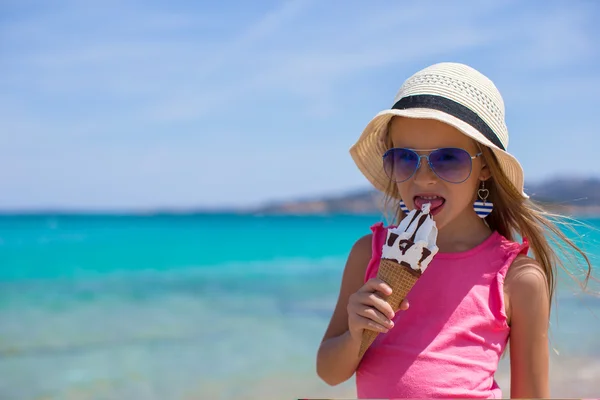 Lilla bedårande flickan äta glass på tropisk strand — Stockfoto