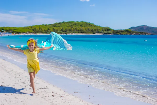 Niña bonita corriendo por la playa con toalla y muy feliz —  Fotos de Stock