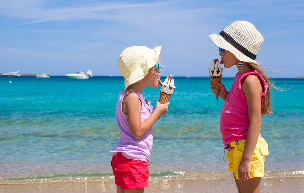 Kis boldog lányok eszik fagylaltot, trópusi tengerparton — Stock Fotó