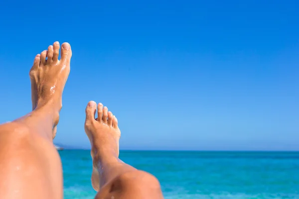 Closeup of female legs background of the turquoise sea — Stock Photo, Image