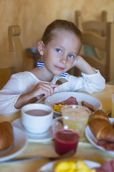 Adorable niña desayunando en el restaurante del resort —  Fotos de Stock