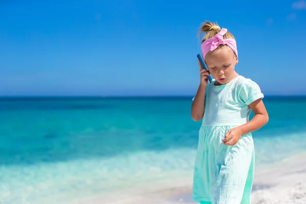 Little adorable girl talking at phone during beach vacation — Stock Photo, Image