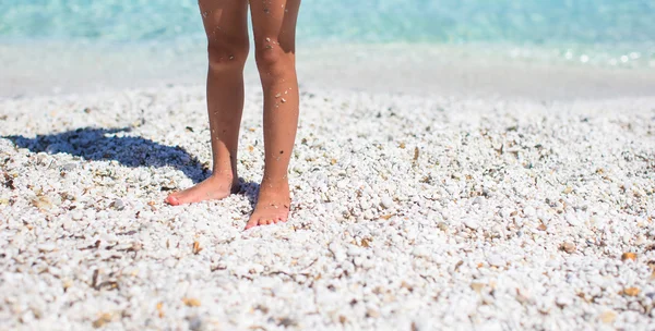 Närbild på en liten flicka fötter på tropisk sandstrand — Stockfoto