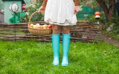 closeup sepet sarı ile kırmızı elma ve lastik çizmeler genç kız