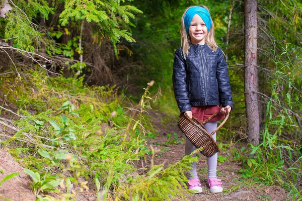 Little happy girl pick up mushrooms in autumn forest — Stock Photo, Image