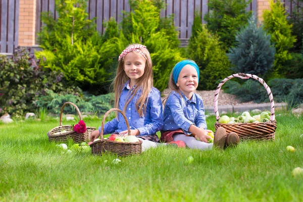 Two little happy girls with great autumn harvest of tomatoes — Stock Photo, Image