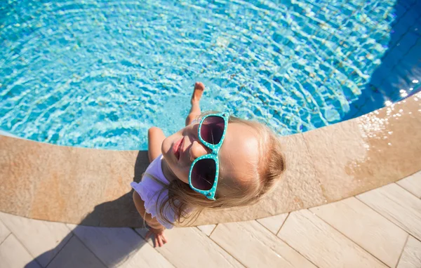 Entzückendes kleines Mädchen in der Nähe des Pools im Tropenurlaub — Stockfoto