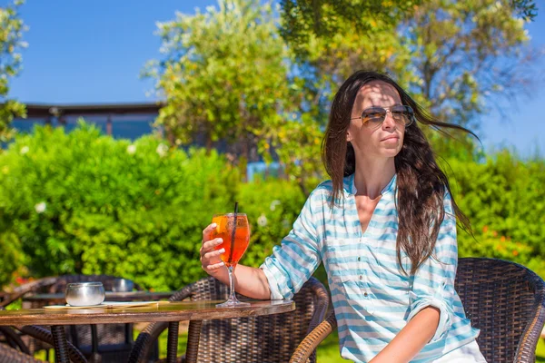 Junge Frau mit Cocktail in tropischem Café in exotischem Resort — Stockfoto