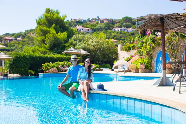 Adorável jovem casal romântico relaxante à beira da piscina — Fotografia de Stock