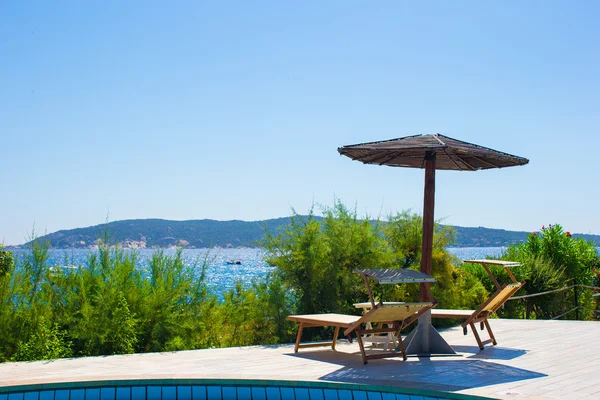 Deck chairs and infinity pool over amazing tropical lagoon — Stock Photo, Image