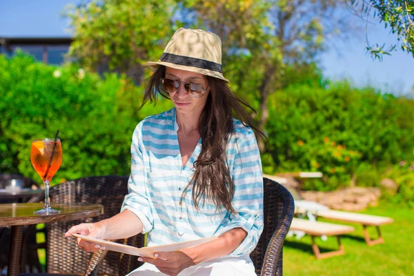 Young beautiful woman with cocktail in oitdoor cafe at exotic resort — Stock Photo, Image