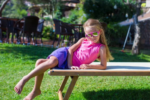 Schattig meisje op strand ligstoel buitenshuis — Stockfoto