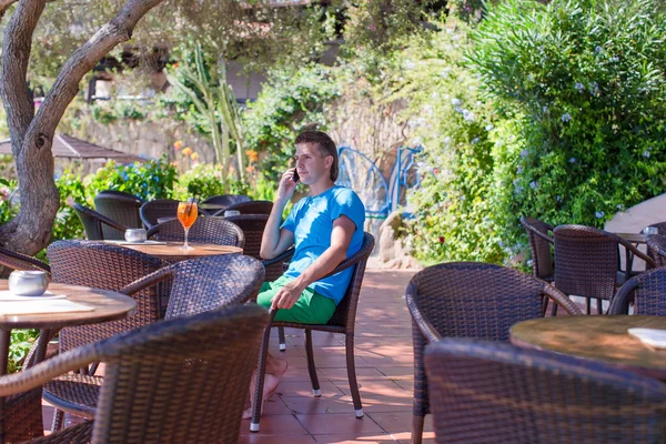 Hombre joven en la cafetería al aire libre hablando por teléfono —  Fotos de Stock