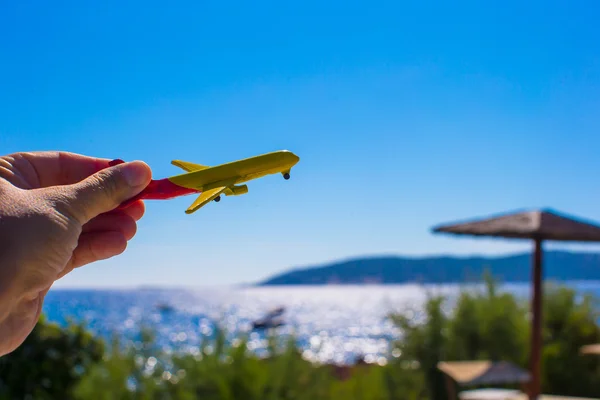 Malé letadlo v ženské ruce na pozadí modré oblohy — Stock fotografie