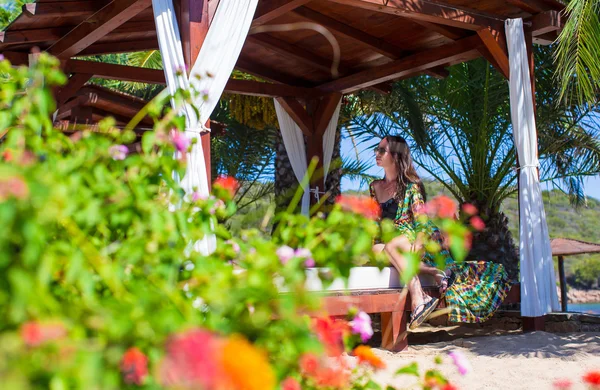 Joven hermosa mujer descansando en la cama de playa durante las vacaciones tropicales —  Fotos de Stock