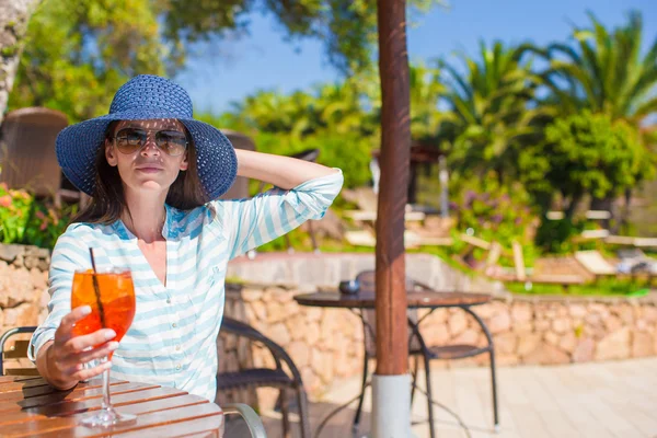 Young woman sitting in tropical cafe near swimming pool — Stock Photo, Image