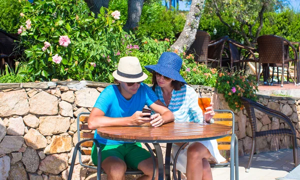 Pareja joven con smartphone en la cafetería al aire libre — Foto de Stock