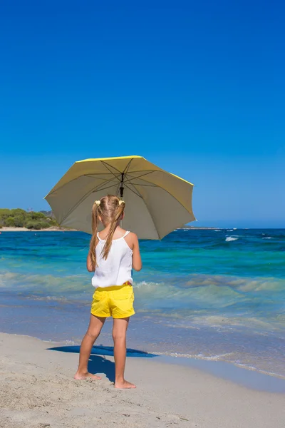 Niña linda con gran paraguas amarillo caminando en la playa tropical —  Fotos de Stock