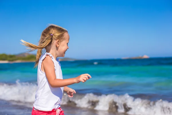 Entzückendes kleines Mädchen spielt während des Tropenurlaubs am weißen Strand — Stockfoto