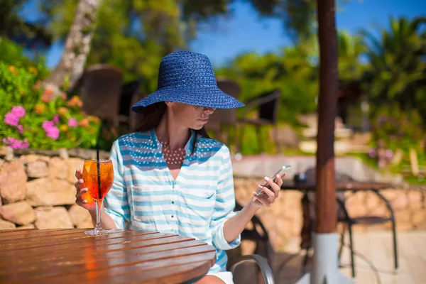 Jonge vrouw met cocktail in tropische café in exotische resort — Stockfoto