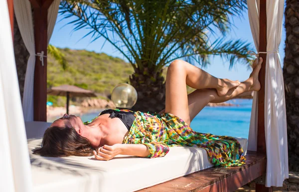 Jovem bela mulher relaxante na cama de praia durante as férias tropicais — Fotografia de Stock