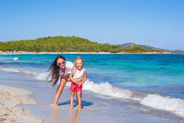 Młoda matka i dziewczynki mają zabawy razem na tropikalnej plaży — Zdjęcie stockowe