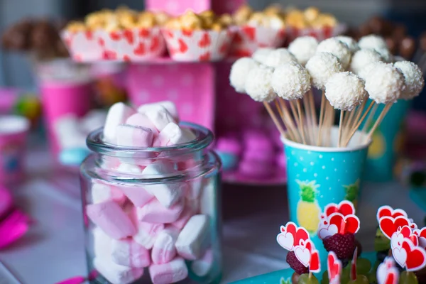 Marshmallow, sweet colored meringues, popcorn, custard cakes and cake pops on table — Stock Photo, Image